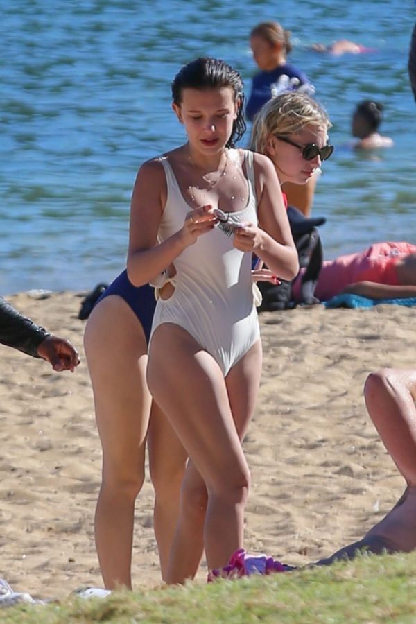 Mit ihre schlanke Körper und Dunkelbraun Haartyp ohne BH (BH-Größe ) auf Strand im Bikini
