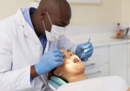 professional male dentist examining woman's teeth